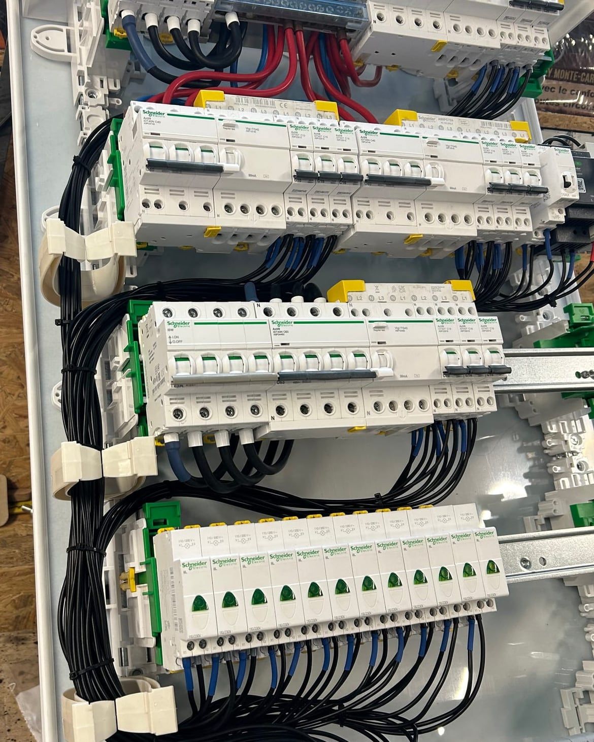 Tableau électrique Schneider en cours de câblage, disjoncteurs alignés et fils peignés